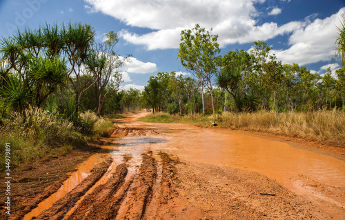 Western Australia – Flooded Outback gravel road after 4WD car crossing the waterhole with muddy water at the savanna