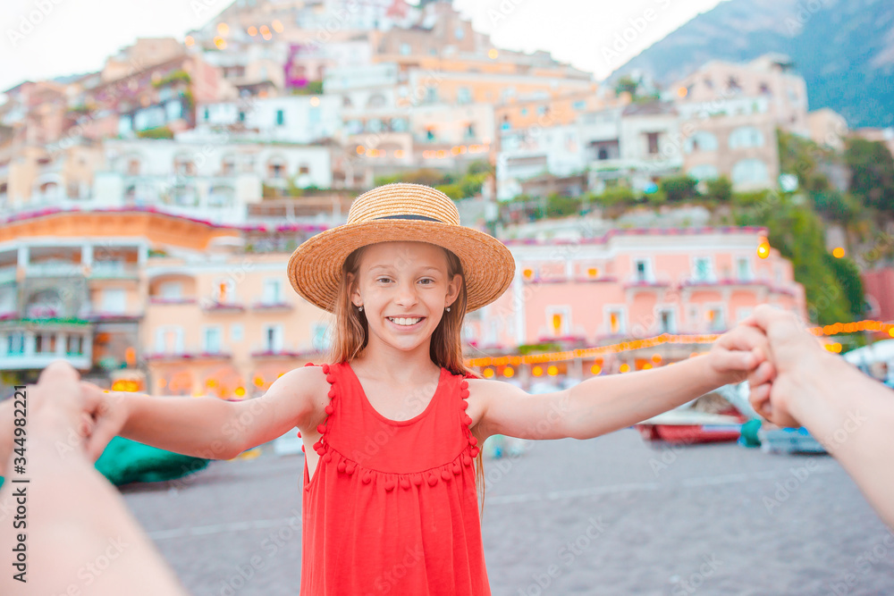 Fototapeta premium Adorable little girl on warm and sunny summer day in Positano town in Italy