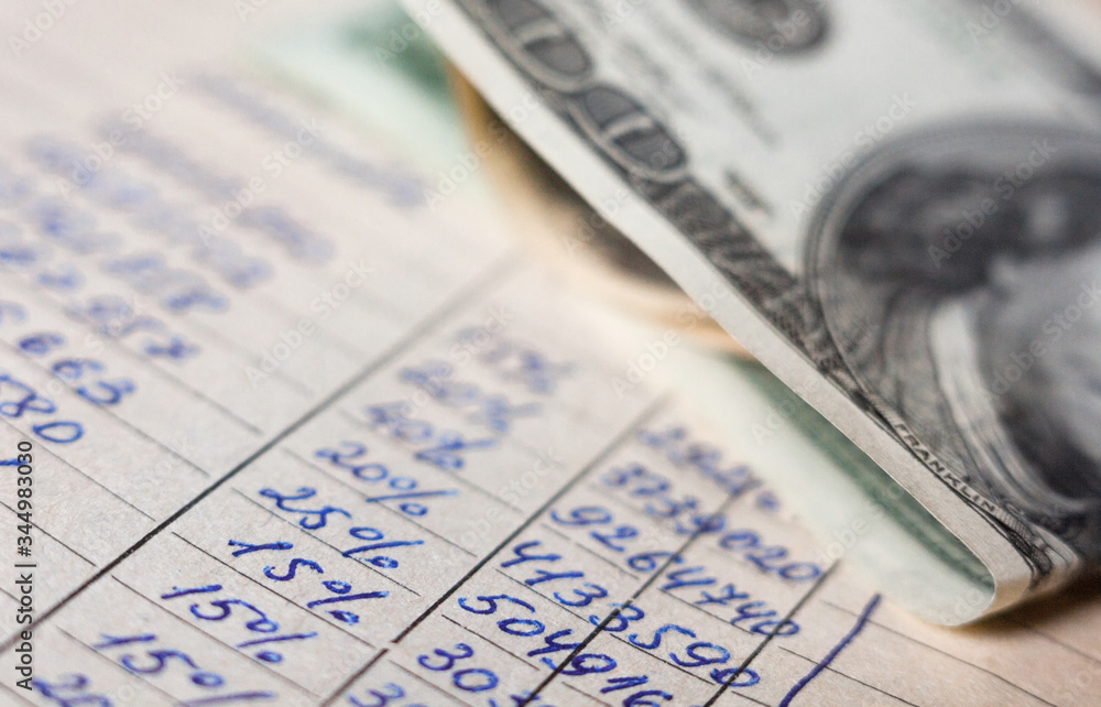 Calculations and 100-dollar bills.