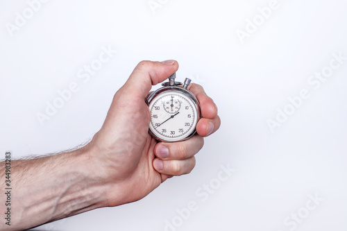 a man's hand with a stopwatch on a white background in the right part of the text space