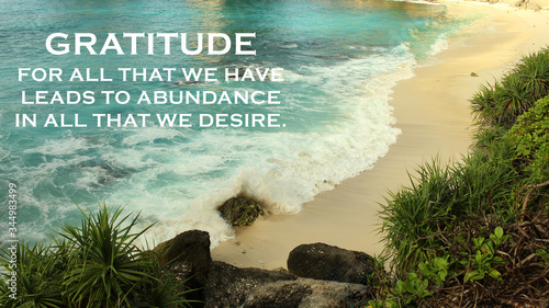 Inspirational quote - Gratitude for all that we have leads to abundance in all that we desire. Gratefulness and happiness concept on background of beautiful beach and sea landscape. photo