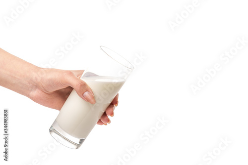 Glass of milk held by afemale hand isolated on white background