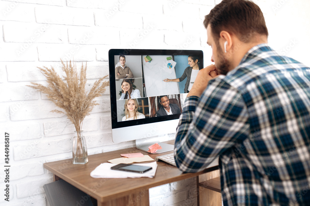 Business team working from home in a video conference. .The guy communicates via video call communication with his business colleagues about the future strategy. Distant work