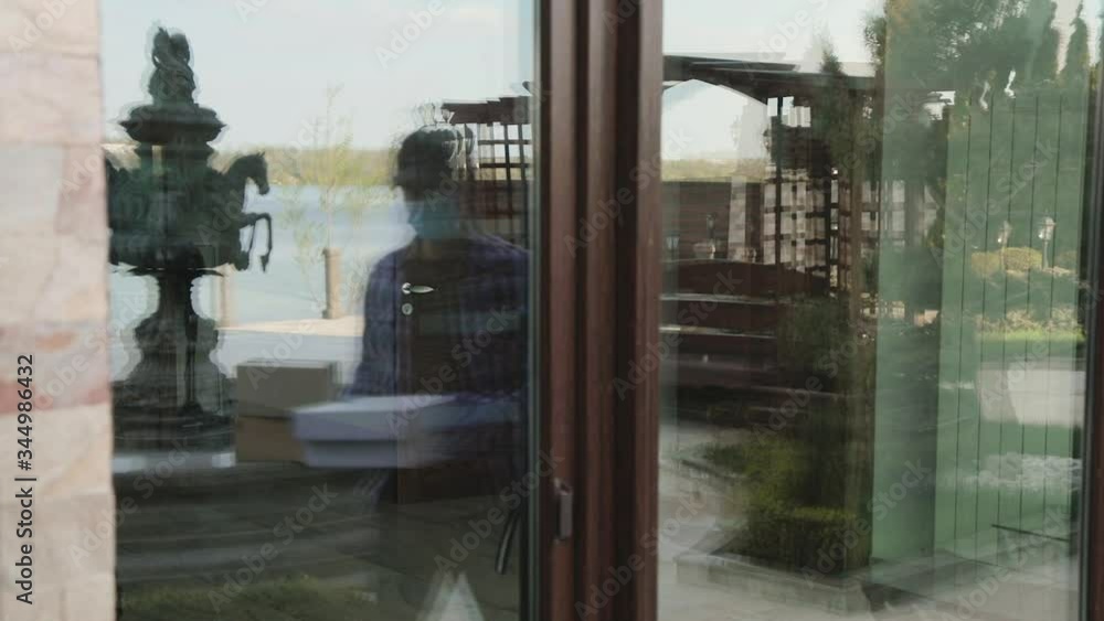 Courier calling a customer to give safe, delivery at home during virus