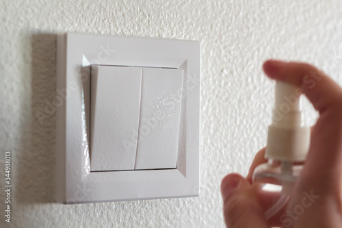 Clean and disinfect light switch with alcohol photo