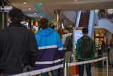 Selected focus, European people queue for enter shopping mall during quarantine and social distancing for COVID-19 virus in Düsseldorf, Germany.