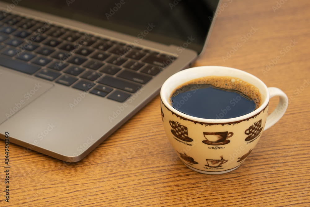 Coffee Cup next to a Computer Coffee Cup next to a Computer