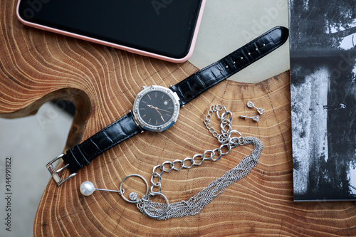 Watch, jewelry, phone on a wooden table