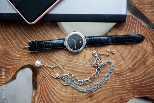 Watch, jewelry, phone on a wooden table
