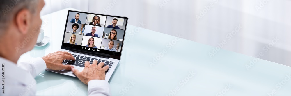 Businessman Videoconferencing With Colleague On Laptop Businessman Videoconferencing With Colleague On Laptop
