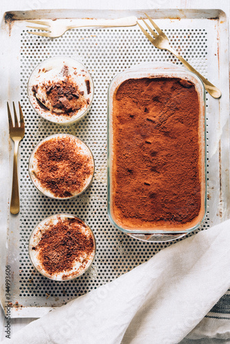 Tiramisu in different shape, various form of serving tiramisu, on glasses, classic, and as a round cake,