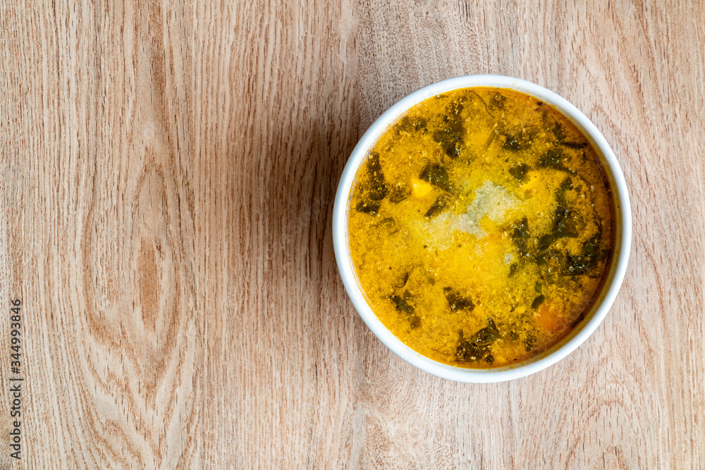 Soup of potatoes, spinach, carrots, meat. Bowl of soup on a wooden background. Copy space Soup of potatoes, spinach, carrots, meat. Bowl of soup on a wooden background. Copy space