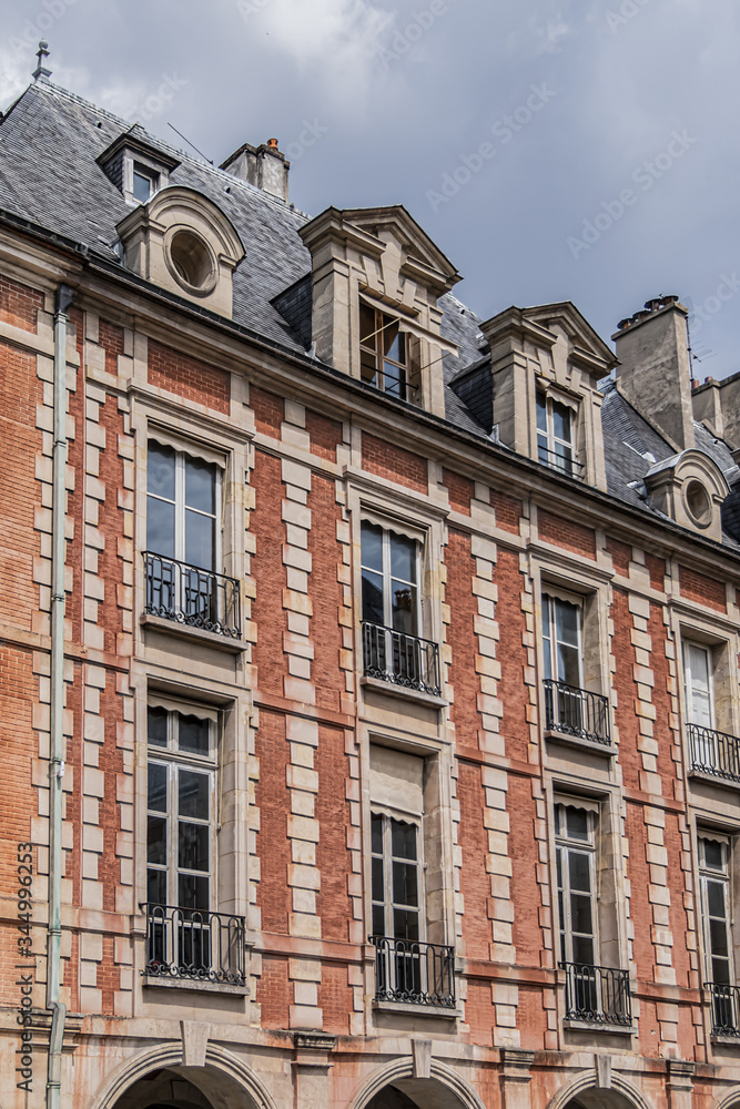 Naklejka premium Typical building at Place des Vosges (known as Place Royale) - oldest planned square in Paris, in Marais district. Place des Vosges built by Henri IV from 1605 to 1612. Paris, France.