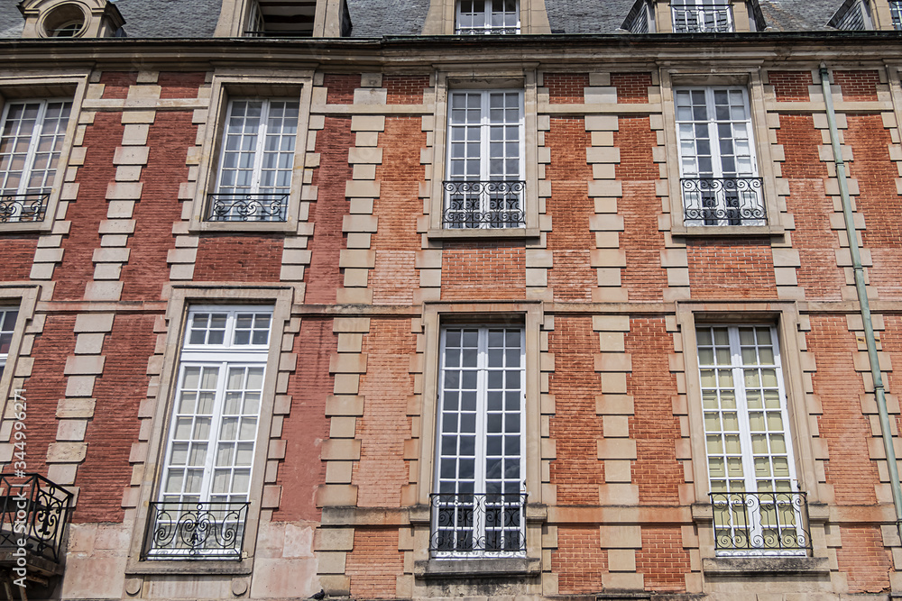Typical building at Place des Vosges (known as Place Royale) - oldest planned square in Paris, in Marais district. Place des Vosges built by Henri IV from 1605 to 1612. Paris, France. Typical building at Place des Vosges (known as Place Royale) - oldest planned square in Paris, in Marais district. Place des Vosges built by Henri IV from 1605 to 1612. Paris, France.