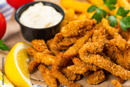 Crispy Breaded Clam Strips Snack Size. Deep Fried Breaded Clams Fingers with Tartar Dipping Sauce. Selective focus.