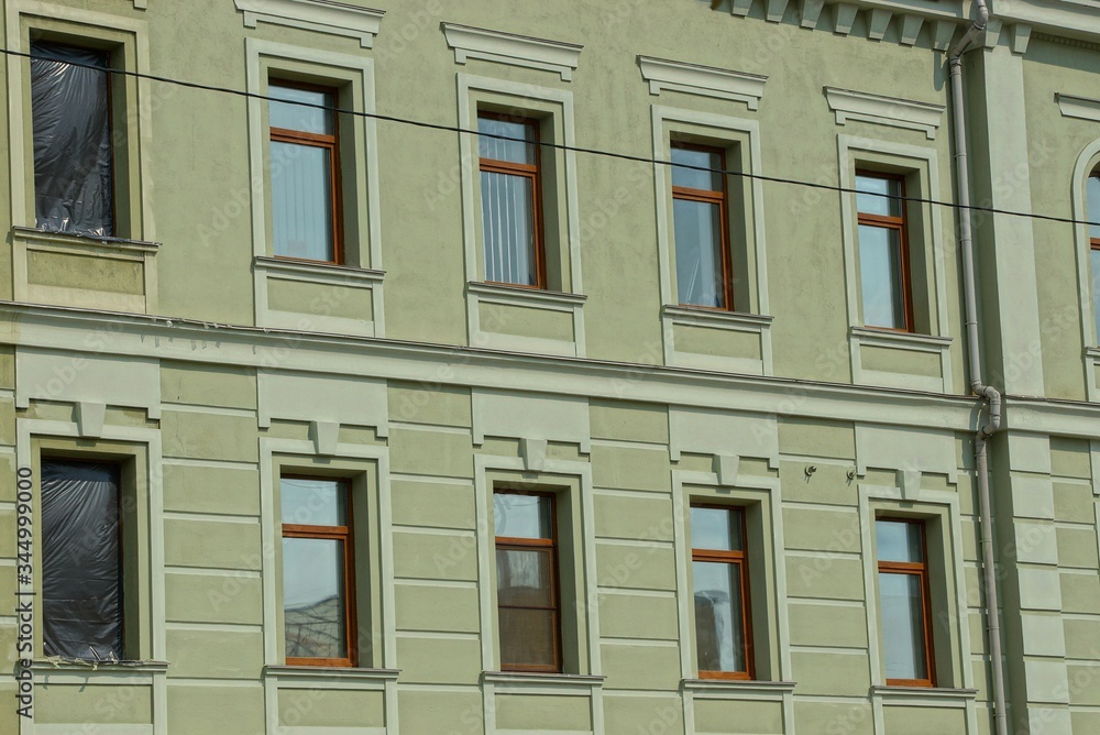Obraz premium texture of a series of windows on the green concrete wall of a building on the street