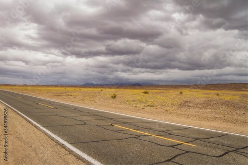 An overcast sky covers the road through Death Valley