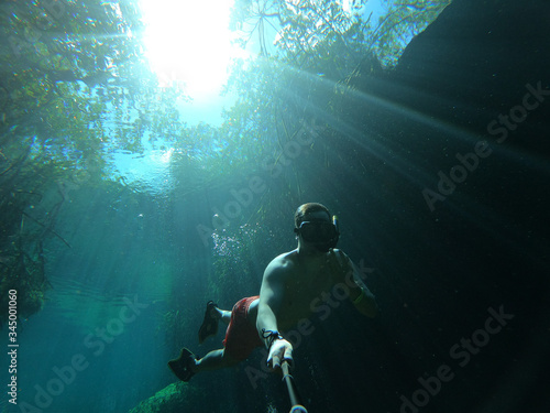 Man takes selfie while freediving in Casa Cenote in Tulum, Quintana Roo, Mexico