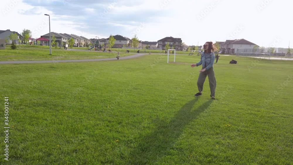 Woman having fun doing summersaults in empty park - wide shot Woman having fun doing summersaults in empty park - wide shot