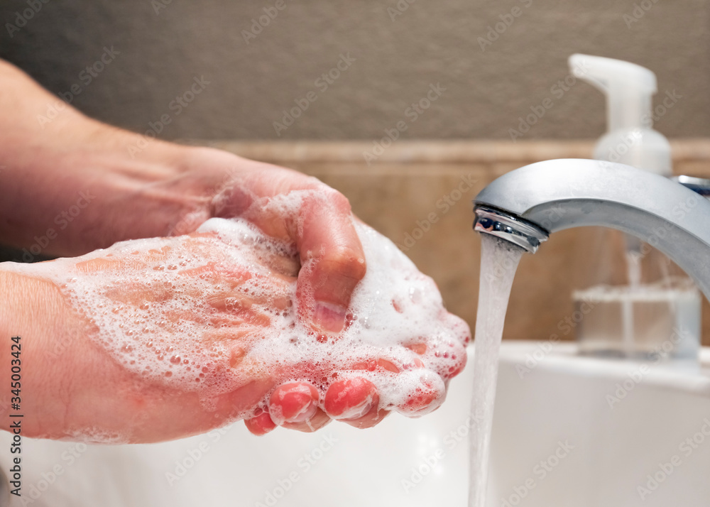 Fototapeta premium Washing hands with soap and water in bathroom sink, protection against viruses and bacteria, hygiene to stay healthy