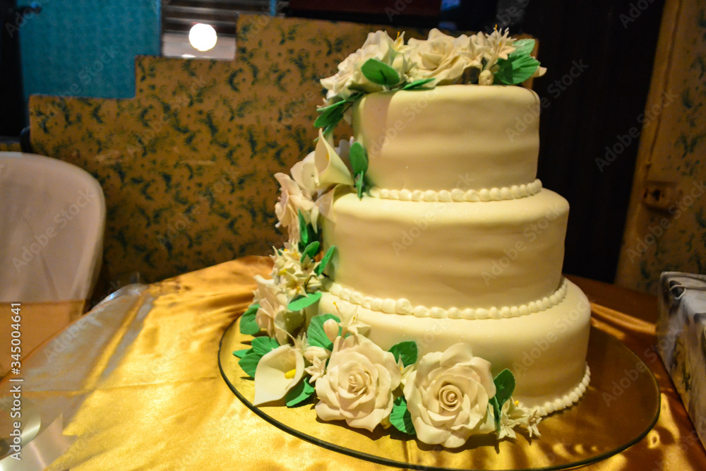 Fototapeta premium Beautiful white cake decorated with white flowers at a wedding.