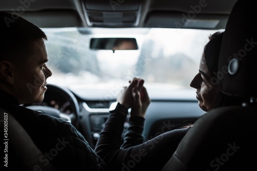 Close up cropped high angle shot of driver husband, lady wife, holding each other's hands, on the road to dreams and happiness, highway, honeymoon, feelings, married family, friendship, destination. © Alex