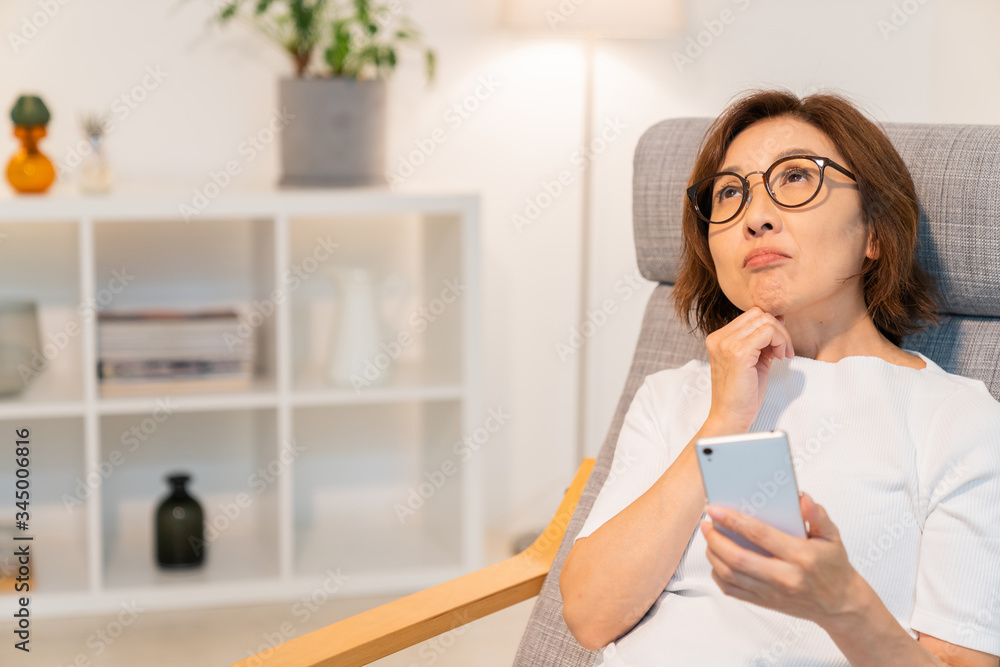 スマートフォンを見るシニア女性 考える スマートフォンを見るシニア女性 考える