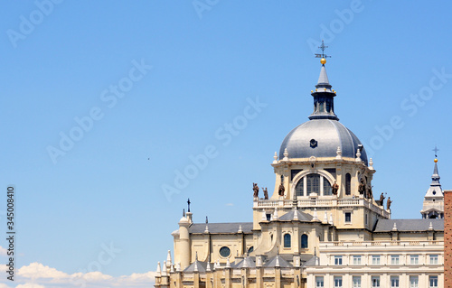 Part of the Almudena cathedral in neoclassicistic style with dome in Madrid against blue sky