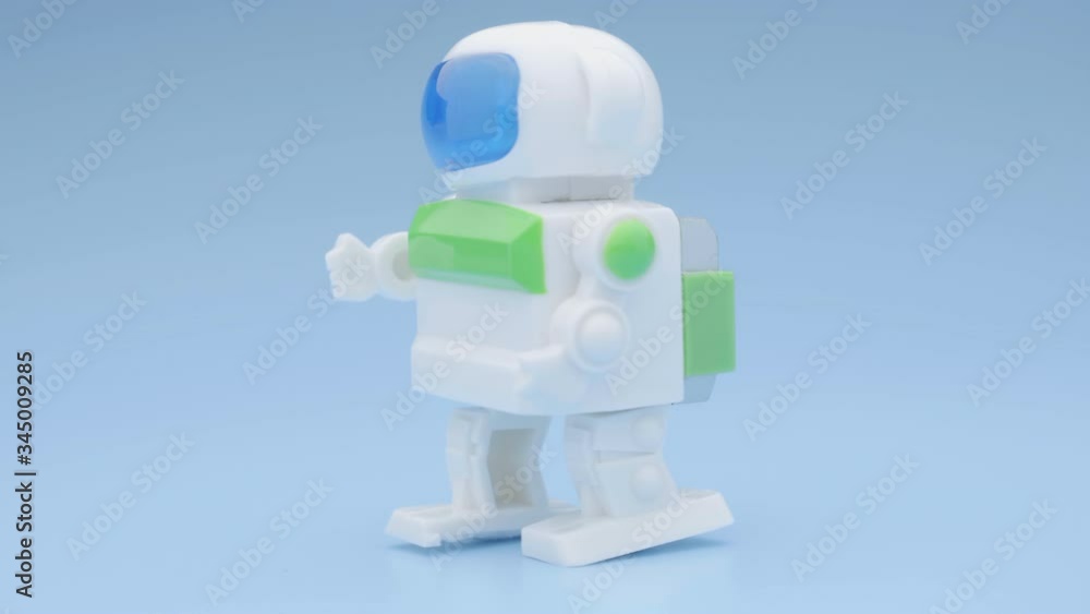 Toy robot dancing. Clockwork robot dancing on blue background. Close up shot. Toy robot dancing. Clockwork robot dancing on blue background. Close up shot.