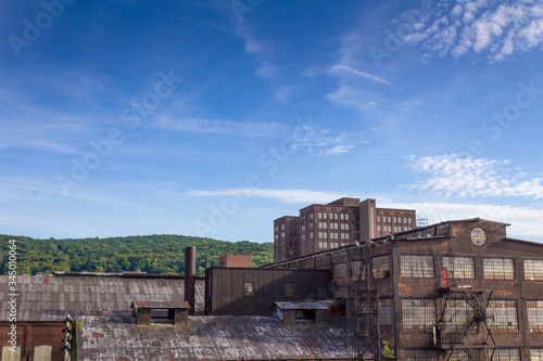 Industrial complex of abandoned and derelict buildings, blue sky copy space overhead, horizontal aspect