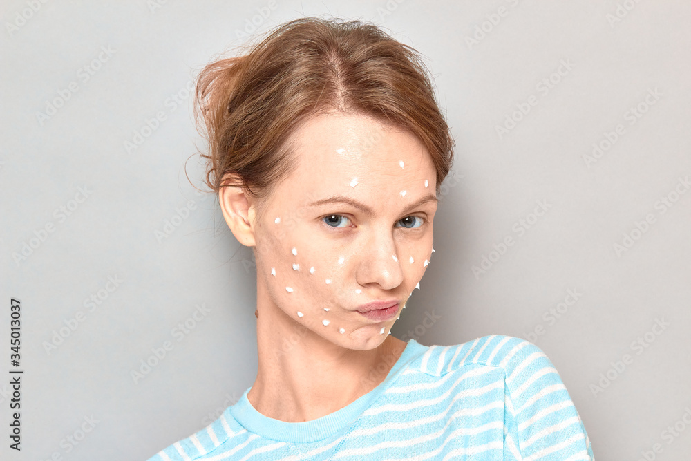 Portrait of funny flirty girl with white drops of face cream on skin Portrait of funny flirty girl with white drops of face cream on skin