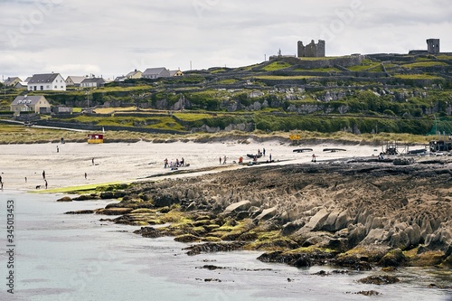 Landscape of Inisheer covered in buildings and greenery under a cloudy sky in Ireland photo