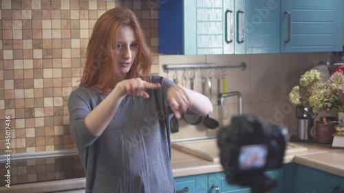 Girl blogger recording vlog for social media. Hipster millennial girl in t-shirt posing in front of camera for blog. Young women vlogger smiling. Female person making video.