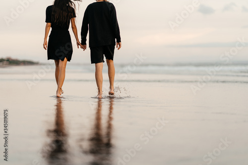Young couple in love, legs of man and woman enjoying romantic evening on sunset