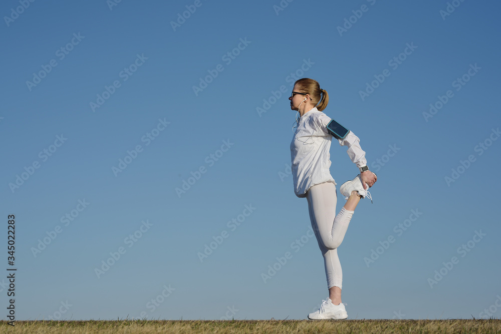 Woman stretching after workout outdoors in the street. Woman stretching after workout outdoors in the street.