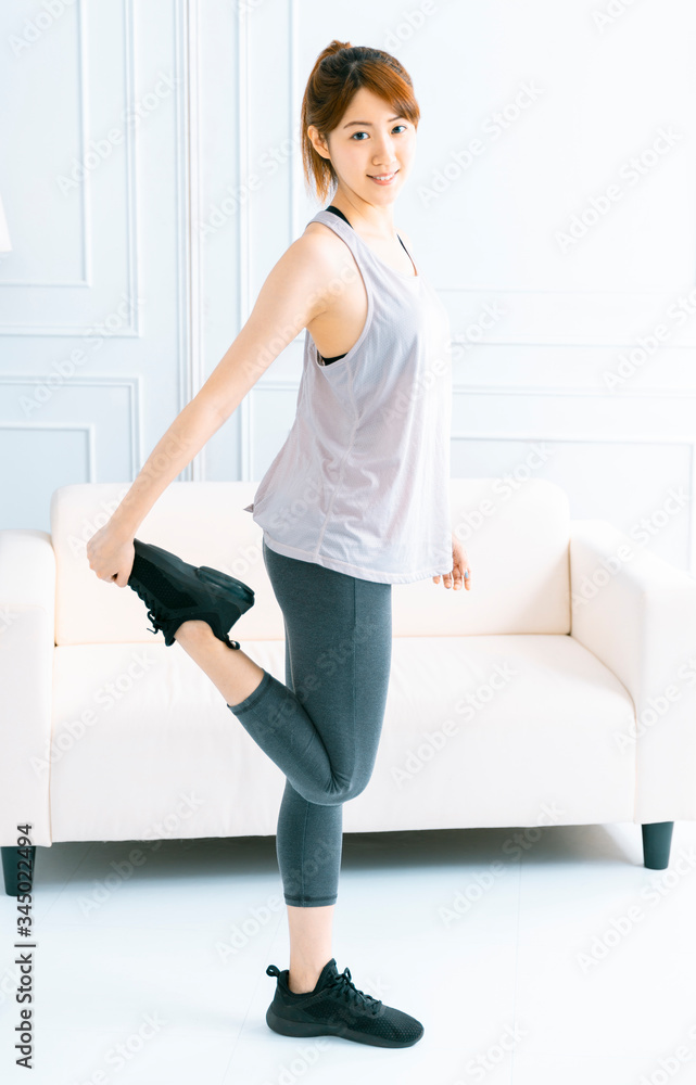 Young woman doing exercise at home in the living room Young woman doing exercise at home in the living room