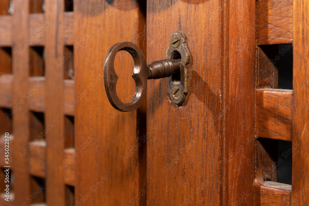 An antique key in an old wooden cupboard An antique key in an old wooden cupboard