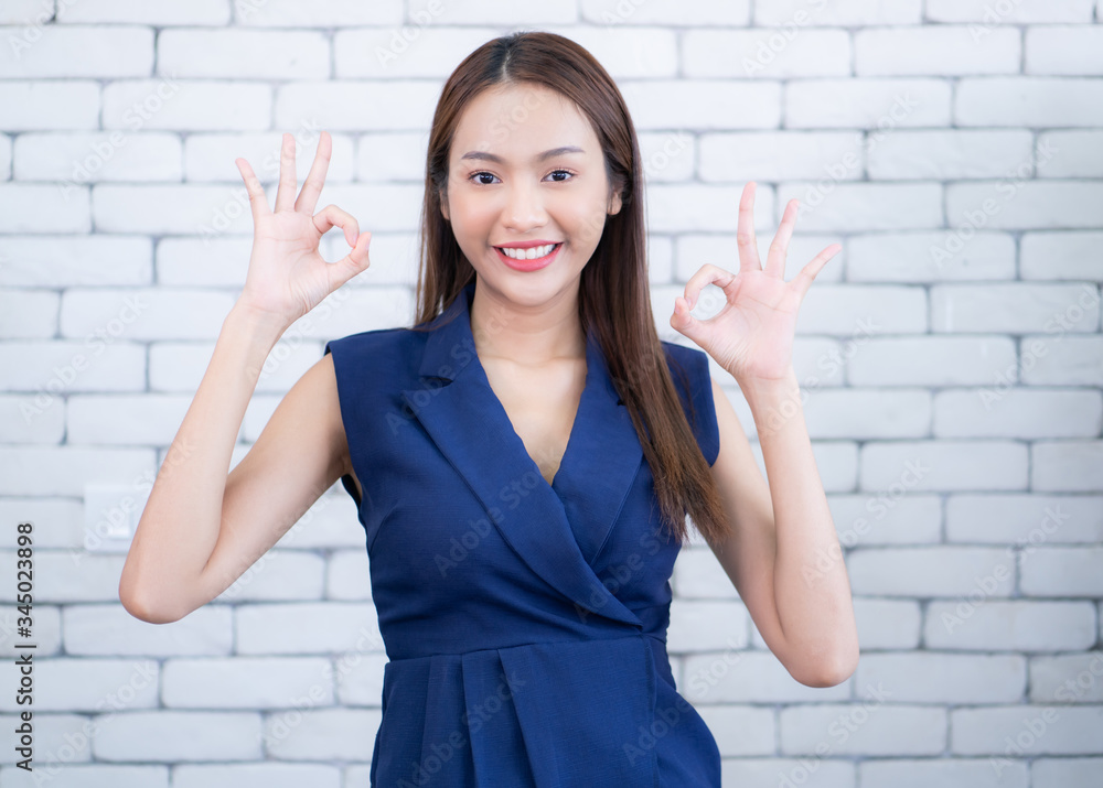 Portrait of beautiful woman wearing dress showing ok sign,Looking at the camera.