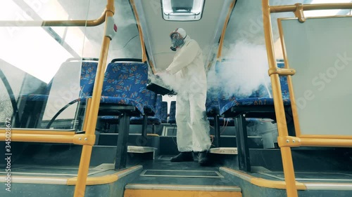 Interior of a bus is getting disinfected with a fumigator photo