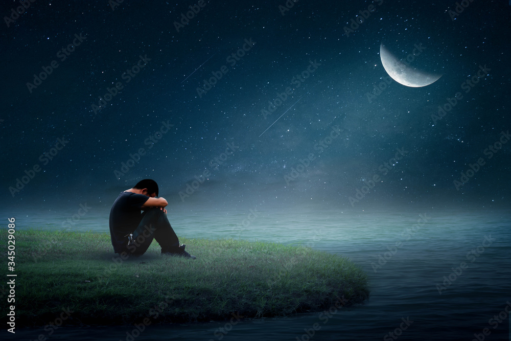 A young man sitting alone on the moon
A young man sitting alone on the moon