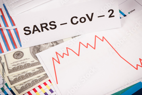 Inscription Sars-CoV-2, currencies dollar and declining chart as risk of financial crisis caused by virus