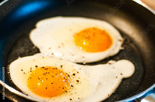 Cooking fried eggs with a liquid yolk in a pan in sunflower oil.