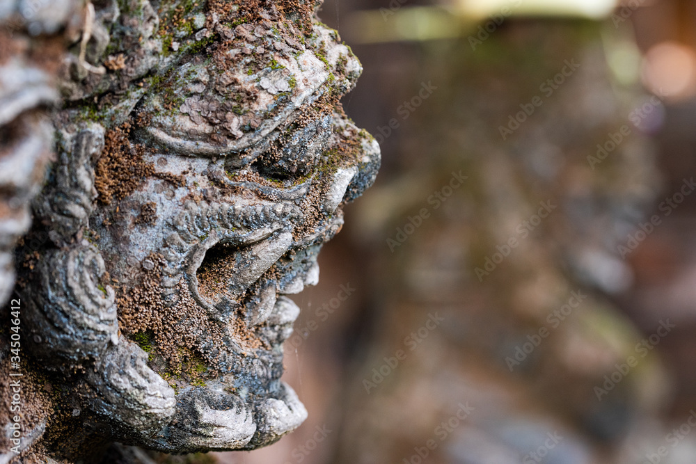 Fototapeta premium Traditional stone statue in Balinese landscape in soft focus