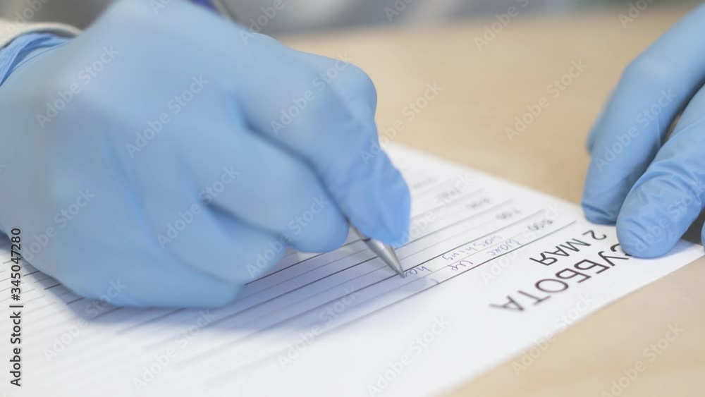 Close up shot of a male hands in medical glove writing a plan for a day during pandemic covid-19 coronavirus quarantine. Most people have to work and study from home. Close up shot of a male hands in medical glove writing a plan for a day during pandemic covid-19 coronavirus quarantine. Most people have to work and study from home.