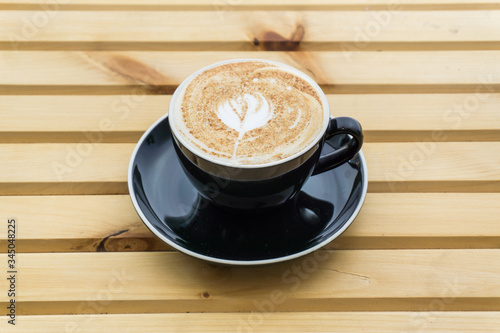 Cappuccino in a cup on a wooden background, product photography