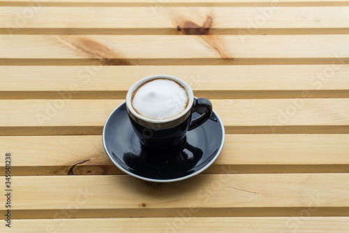Macchiato in a cup on a wooden background, product photography
