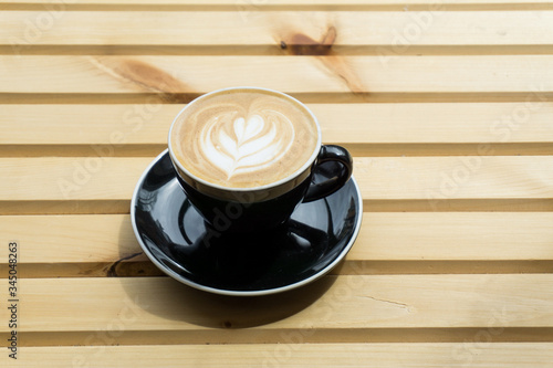 Cappuccino in a cup on a wooden background, product photography