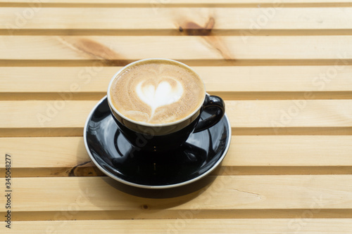 Cappuccino in a cup on a wooden background, product photography