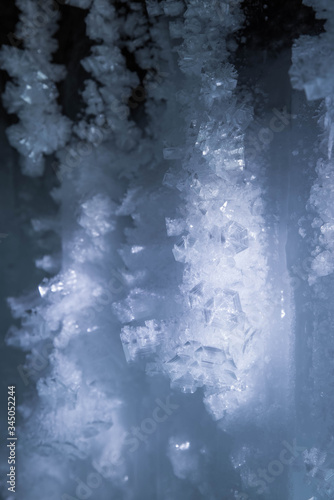 Blue crystal ice grotto cave with icicles, broken ice and snow. Winter landscape.  © strigana