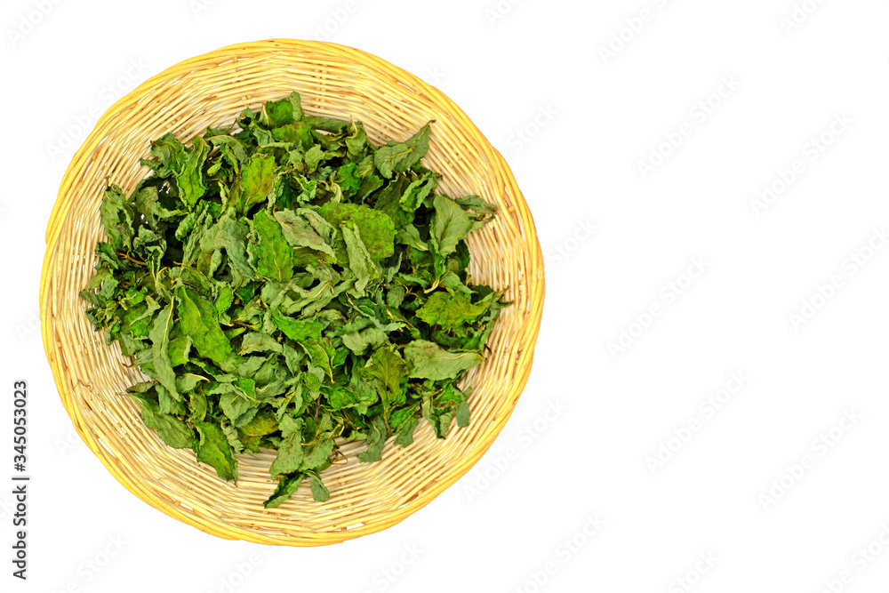 Top view dried organic peppermint leaves for herbal drink tea in the basket isolate on white background. Top view dried organic peppermint leaves for herbal drink tea in the basket isolate on white background.